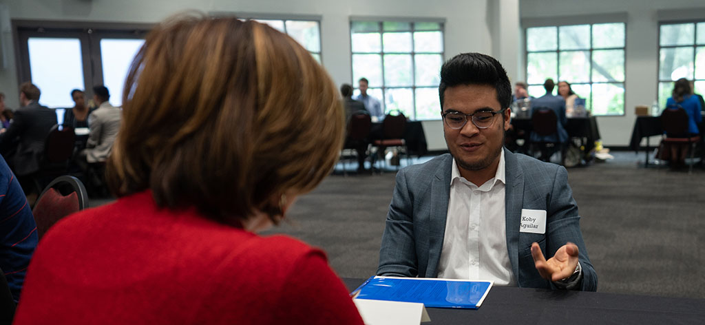 Student and community leader talking at a table